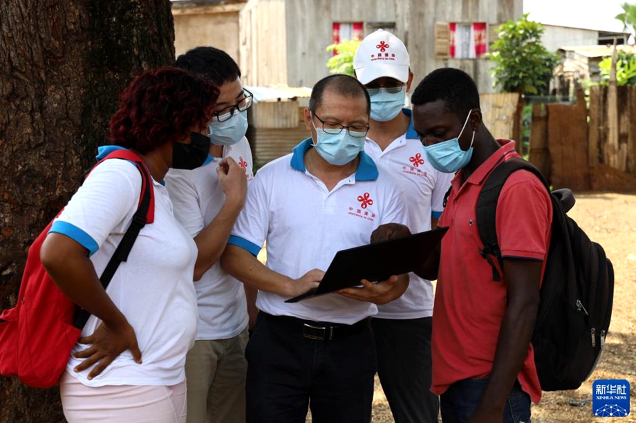 这幅2022年1月25日拍摄的资料照片显示，在圣多美和普林西比（简称圣普）首都圣多美郊区，中国援圣普抗疟专家组与当地志愿者开展抗疟工作。